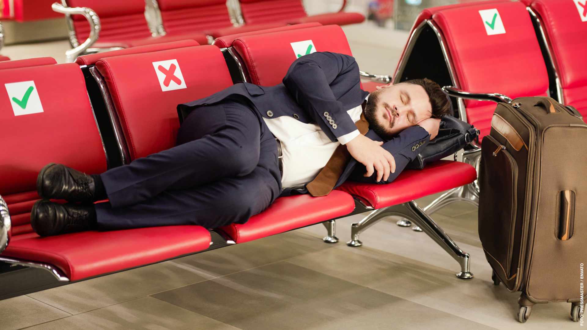 Businessman in suit sleeping in waiting room of the airport terminal waiting for his departure