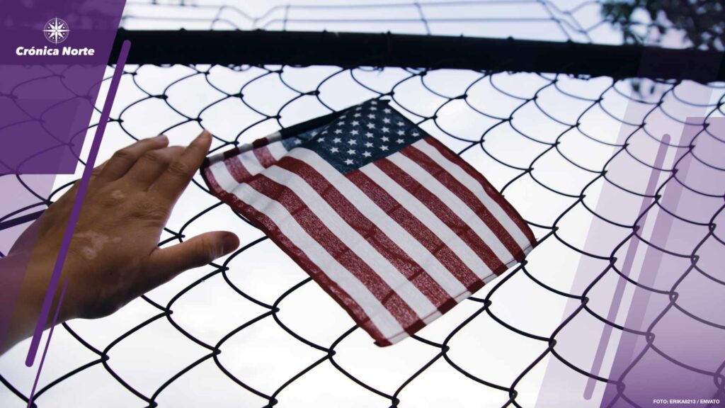 Hand holding america flag in front of a barbed fence. Illegal im